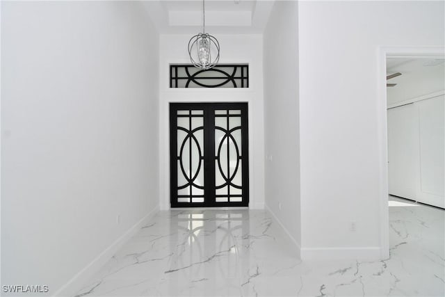 foyer featuring french doors and an inviting chandelier