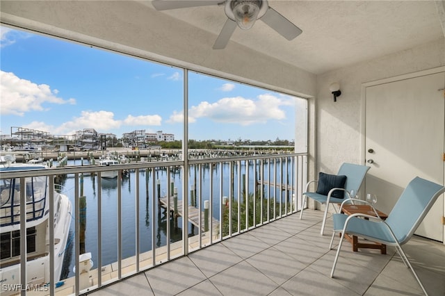 unfurnished sunroom with ceiling fan and a water view