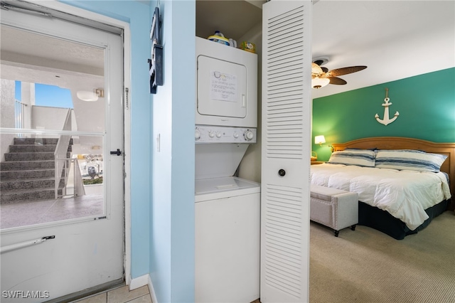 bedroom with ceiling fan and stacked washer / drying machine