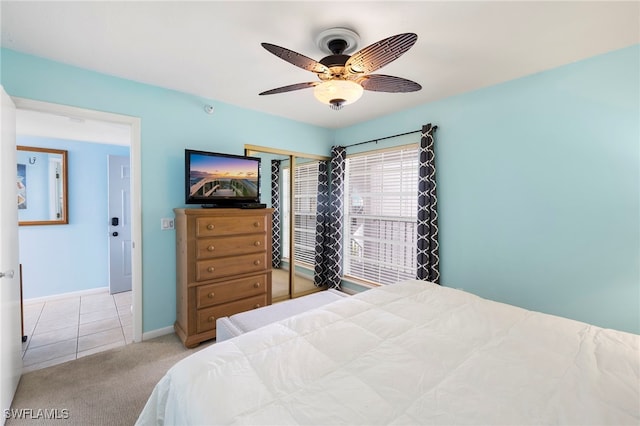 bedroom featuring ceiling fan, light colored carpet, and a closet