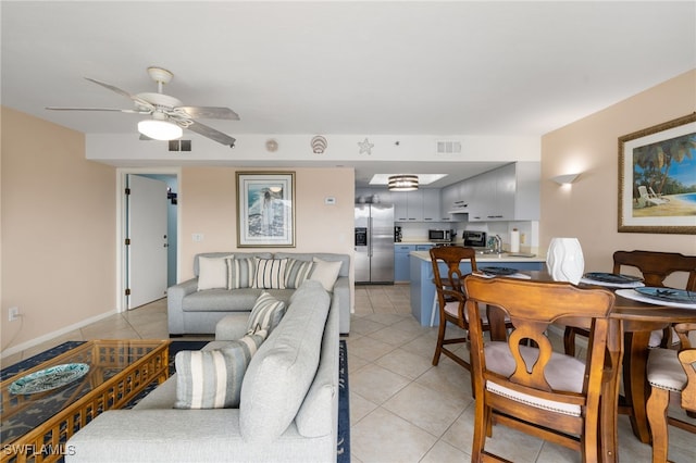 living room with sink, ceiling fan, and light tile patterned floors