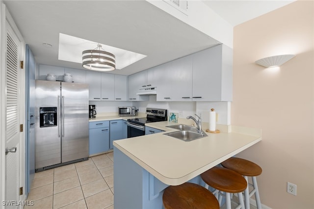 kitchen featuring a kitchen breakfast bar, sink, white cabinetry, light tile patterned flooring, and stainless steel appliances