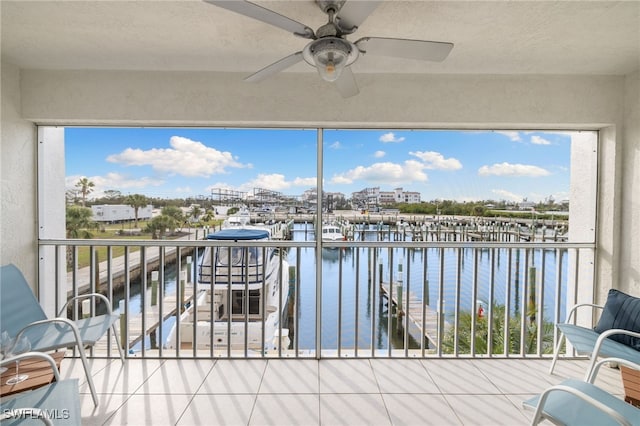 unfurnished sunroom with ceiling fan and a water view