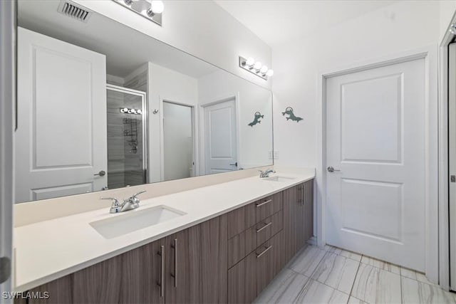 bathroom with a shower with shower door and vanity