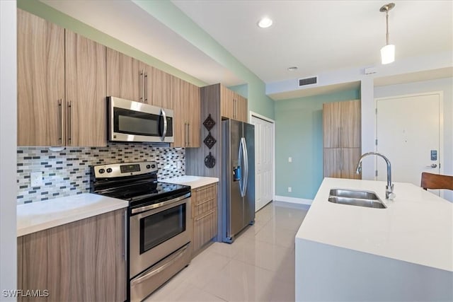 kitchen featuring stainless steel appliances, tasteful backsplash, light tile patterned flooring, pendant lighting, and sink