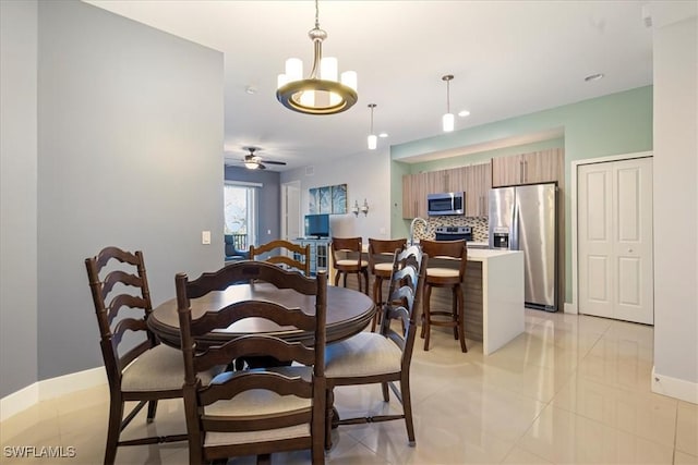 tiled dining space featuring ceiling fan with notable chandelier