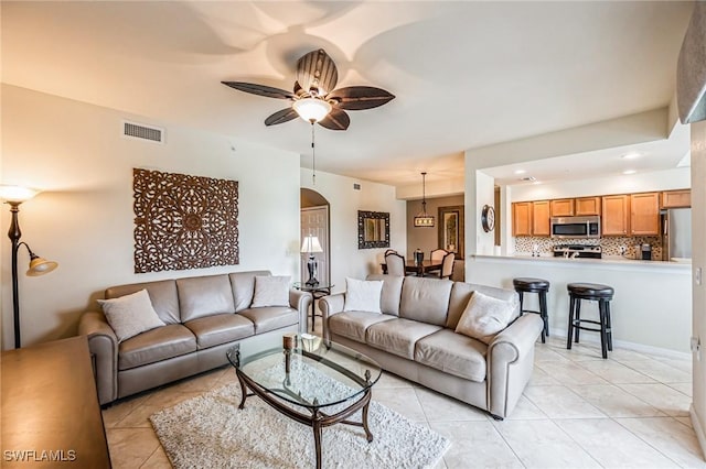 tiled living room featuring ceiling fan