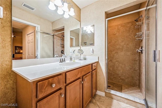 bathroom with vanity, an inviting chandelier, an enclosed shower, and tile patterned flooring