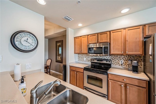 kitchen featuring sink, appliances with stainless steel finishes, and tasteful backsplash