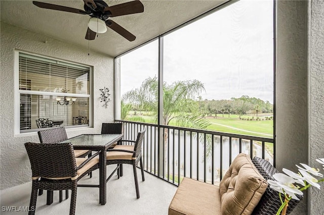 sunroom / solarium with ceiling fan with notable chandelier