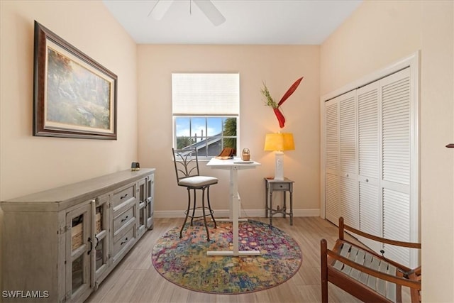 sitting room with light wood-type flooring and ceiling fan