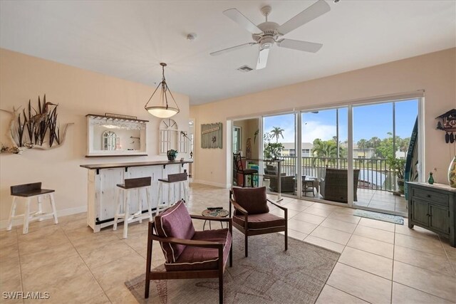 living area with ceiling fan and light tile patterned floors