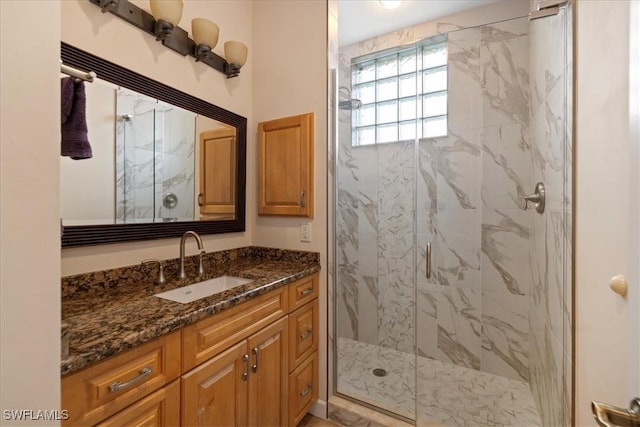 bathroom featuring a shower with door and vanity