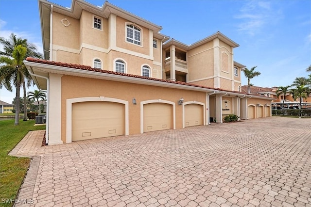 exterior space featuring central AC, a balcony, and a garage