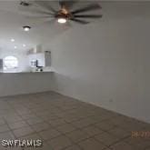 tiled empty room featuring ceiling fan