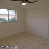 tiled empty room with ceiling fan