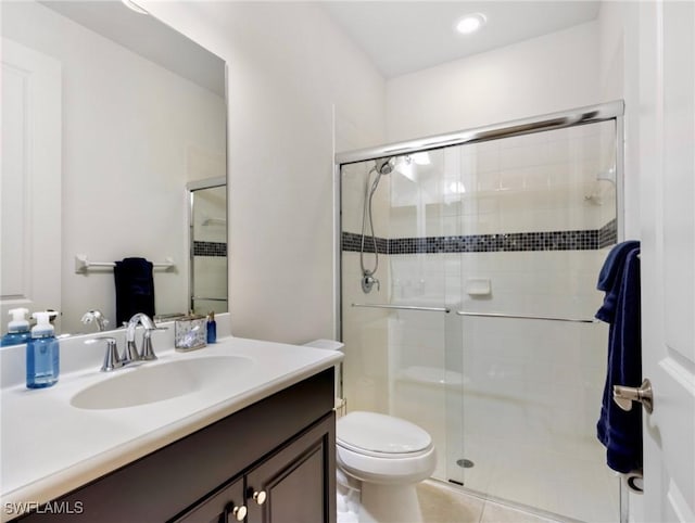 bathroom featuring vanity, toilet, tile patterned floors, and a shower with shower door