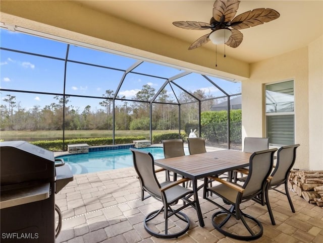 view of patio with glass enclosure, grilling area, and ceiling fan