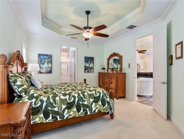 carpeted bedroom with ceiling fan, a raised ceiling, ensuite bath, and ornamental molding