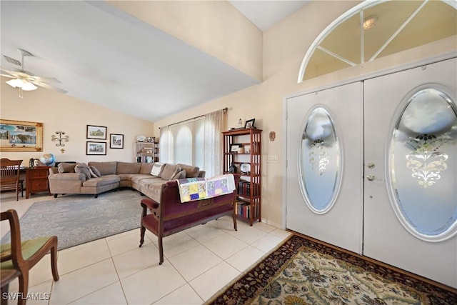 foyer with vaulted ceiling, light tile patterned flooring, and ceiling fan