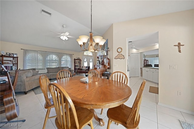 tiled dining room with lofted ceiling and ceiling fan with notable chandelier