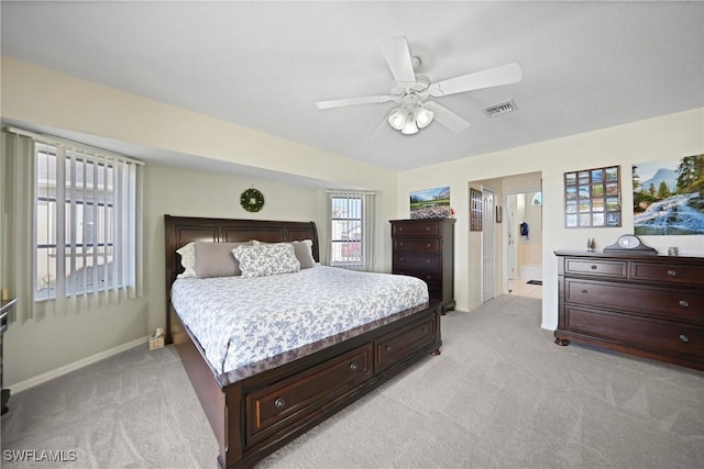 bedroom featuring connected bathroom, light colored carpet, and ceiling fan