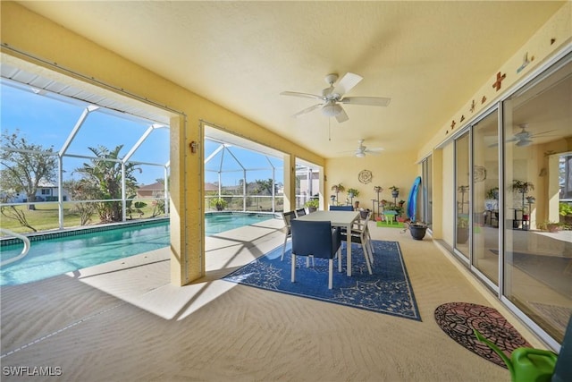 view of pool with a patio, ceiling fan, and glass enclosure