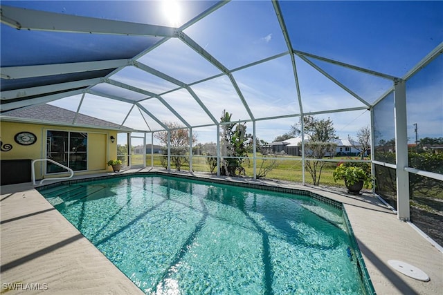 view of pool with a patio area and glass enclosure