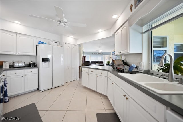 kitchen with white refrigerator with ice dispenser, sink, and white cabinets