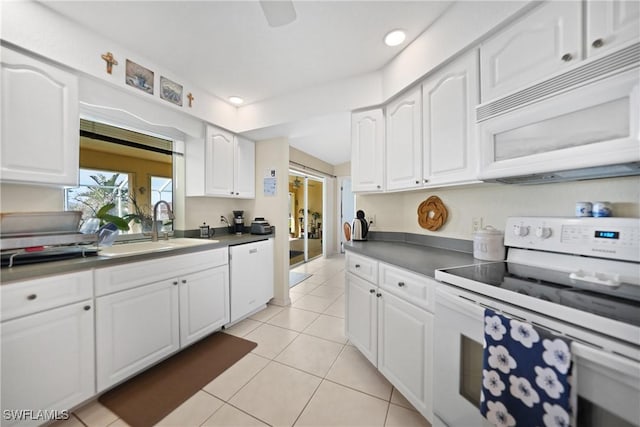 kitchen with sink, white appliances, white cabinets, and light tile patterned flooring