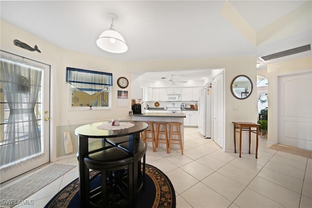 tiled dining room featuring lofted ceiling and ceiling fan