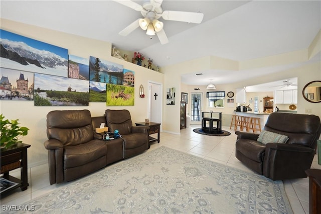 living room with lofted ceiling, light tile patterned floors, and ceiling fan