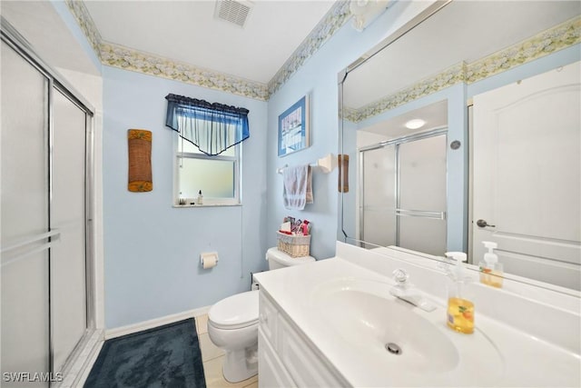 bathroom with vanity, tile patterned flooring, toilet, and walk in shower