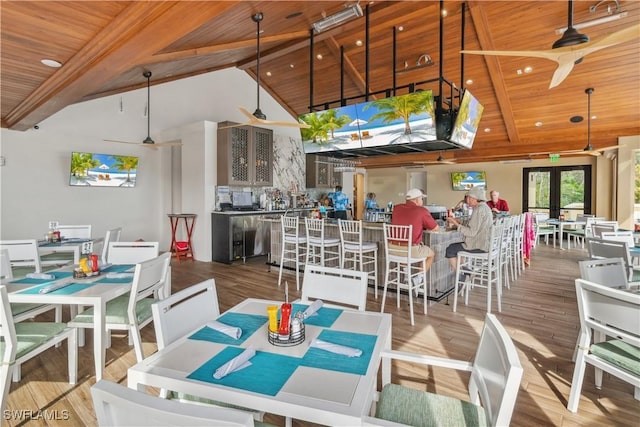 dining room featuring wood ceiling, hardwood / wood-style flooring, beamed ceiling, and french doors