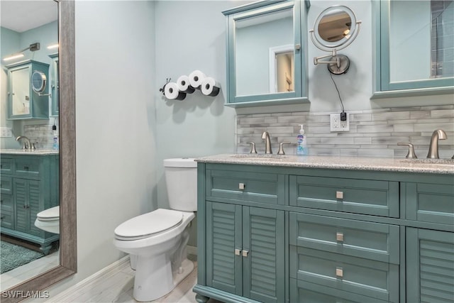 bathroom featuring backsplash, toilet, and vanity