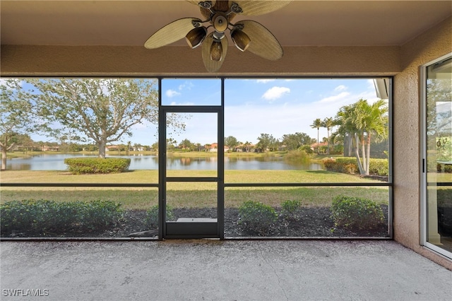 unfurnished sunroom with a water view and ceiling fan