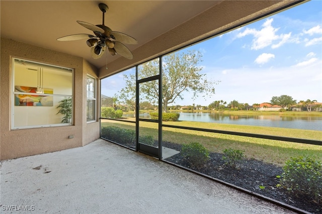 unfurnished sunroom featuring a water view and ceiling fan