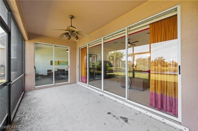 unfurnished sunroom featuring ceiling fan