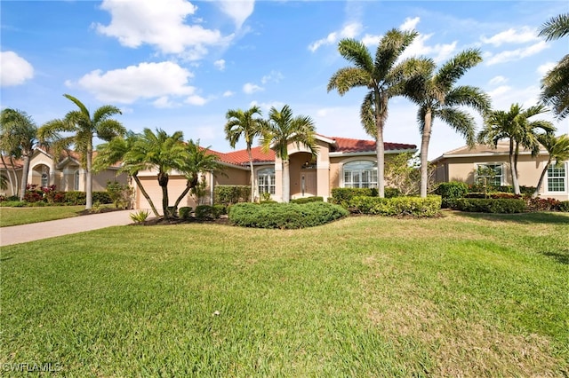 mediterranean / spanish house featuring a garage and a front yard