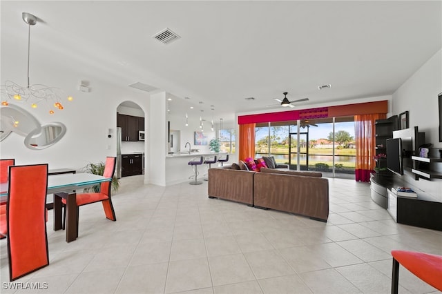 tiled living room featuring ceiling fan and sink