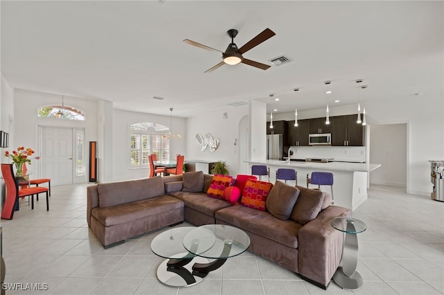 tiled living room with ceiling fan