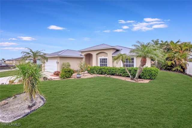 mediterranean / spanish-style home with a garage and a front lawn