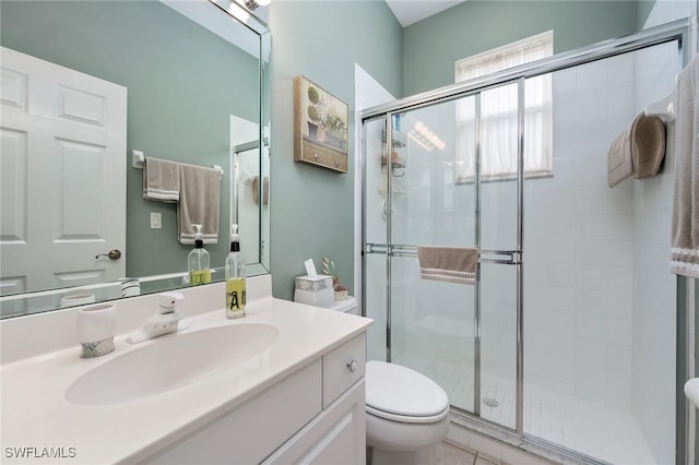 bathroom featuring an enclosed shower, vanity, and toilet