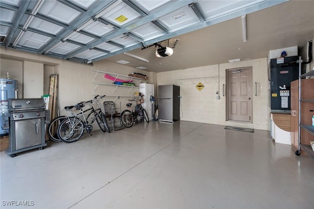 garage featuring electric water heater, a garage door opener, and stainless steel refrigerator