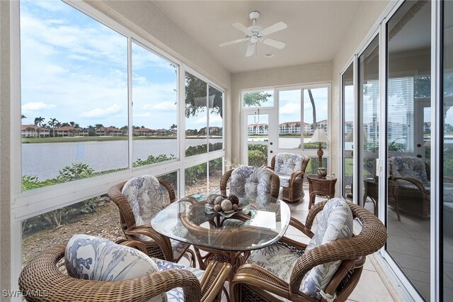 sunroom / solarium with a water view and ceiling fan