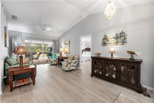 living room with ceiling fan, light hardwood / wood-style flooring, and lofted ceiling