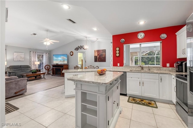 kitchen with white cabinetry, sink, a kitchen island, stainless steel appliances, and lofted ceiling