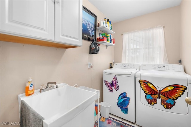 washroom with cabinets, sink, and washing machine and clothes dryer