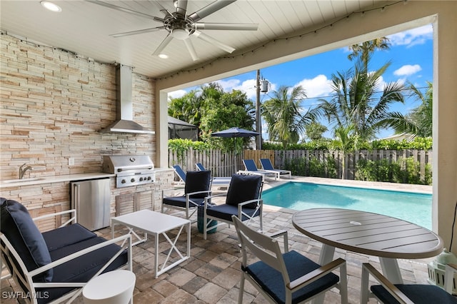 view of swimming pool with an outdoor kitchen, sink, grilling area, ceiling fan, and a patio