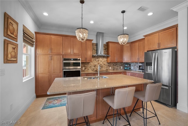 kitchen with stainless steel appliances, tasteful backsplash, light stone counters, an island with sink, and wall chimney exhaust hood